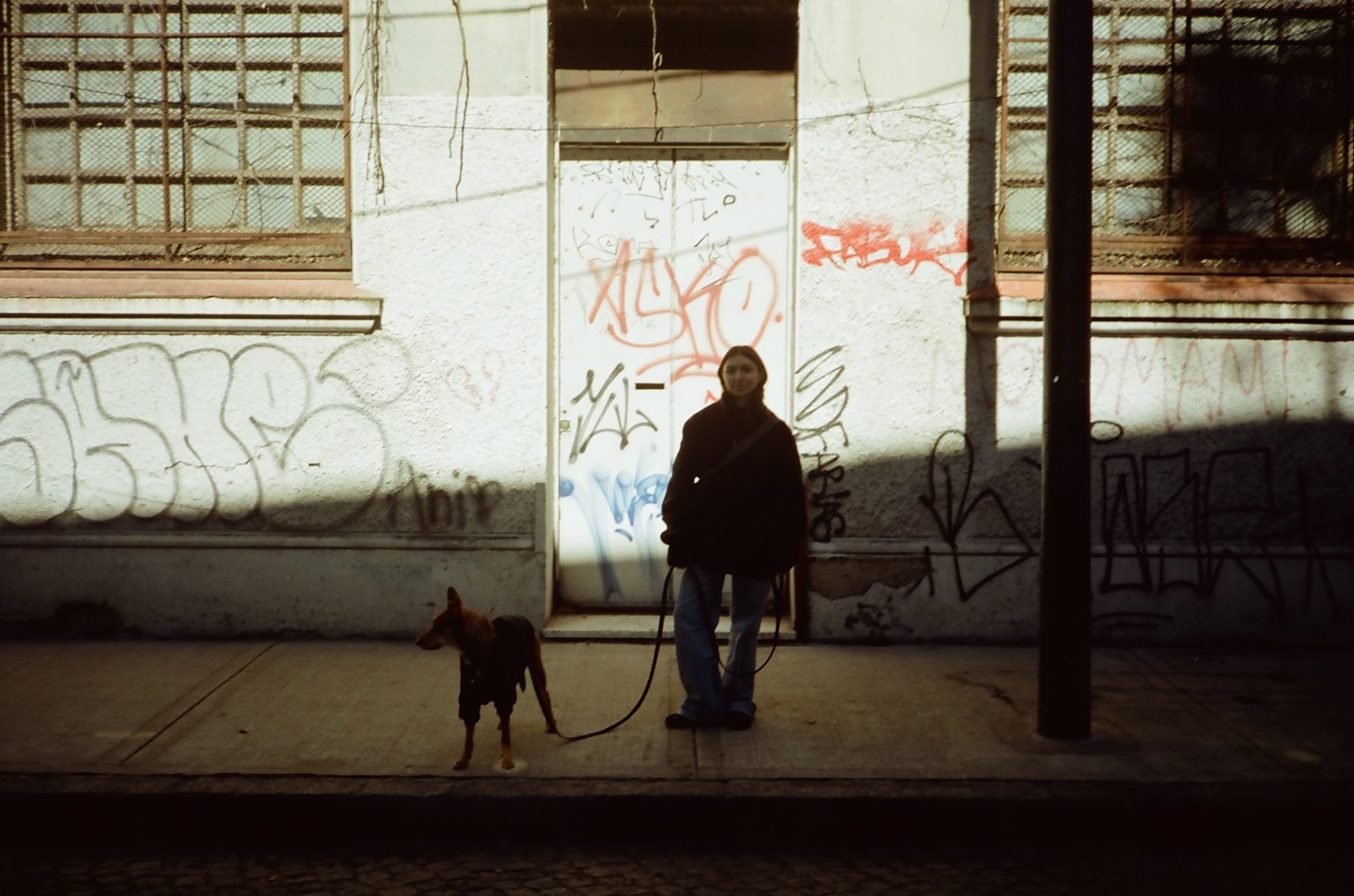 Mujer y perro recortados por un rayo de luz en una estación